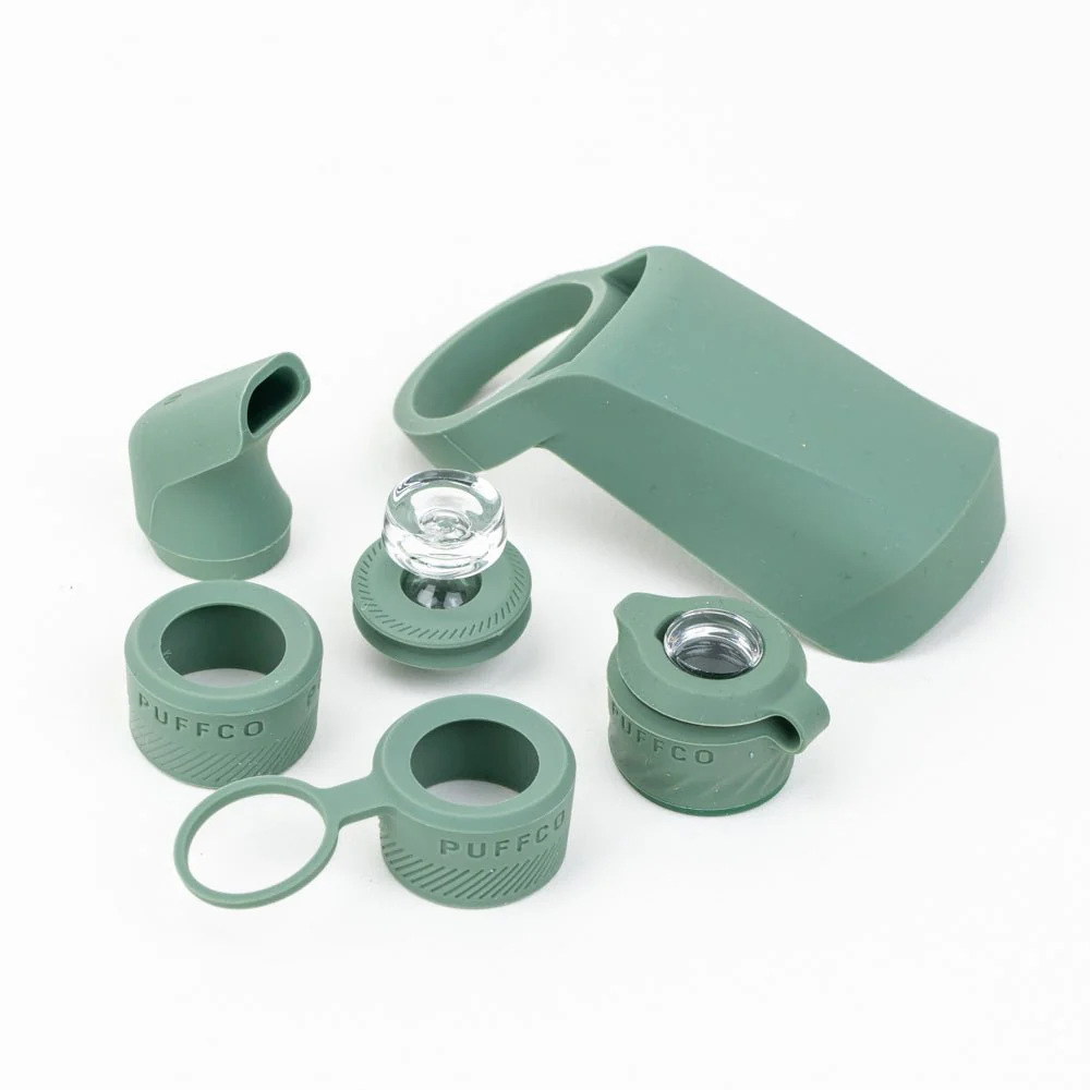 various green-colored plastic components, including a large piece and several smaller pieces, arranged on a white background.