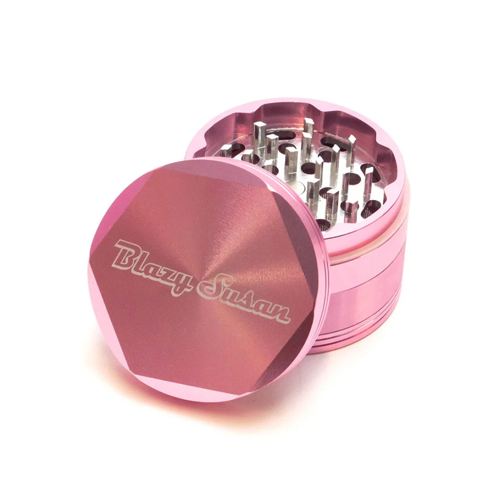 A pink metal grinder with a hexagonal lid, containing multiple small metal grinders.