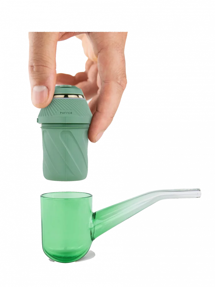 A hand is holding a green electronic cigarette device, which appears to be a puffco product.