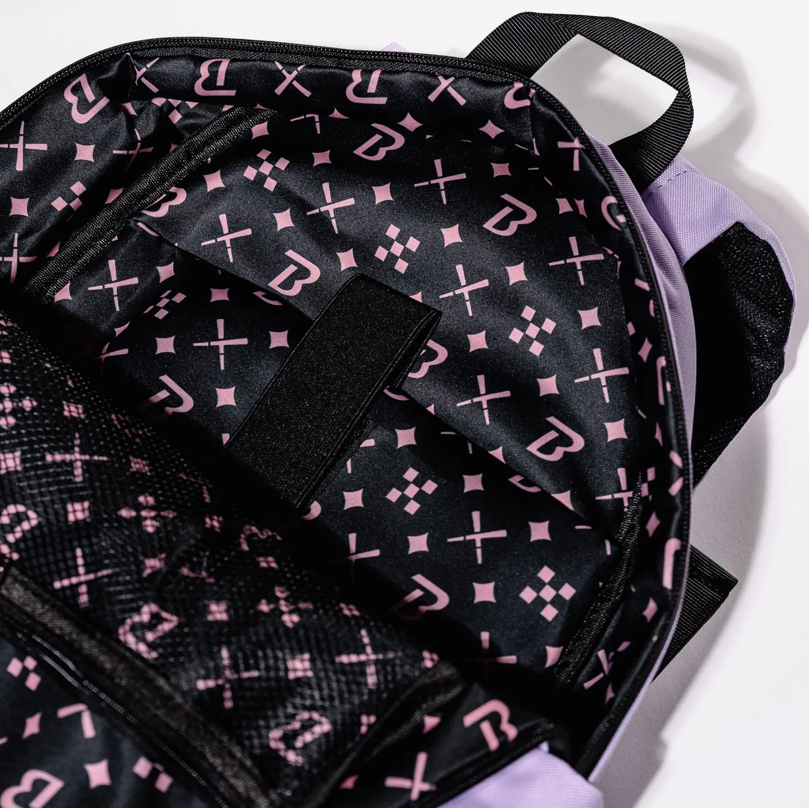 the interior of a backpack with a black and pink patterned fabric. The backpack appears to be empty, with no visible contents or items.