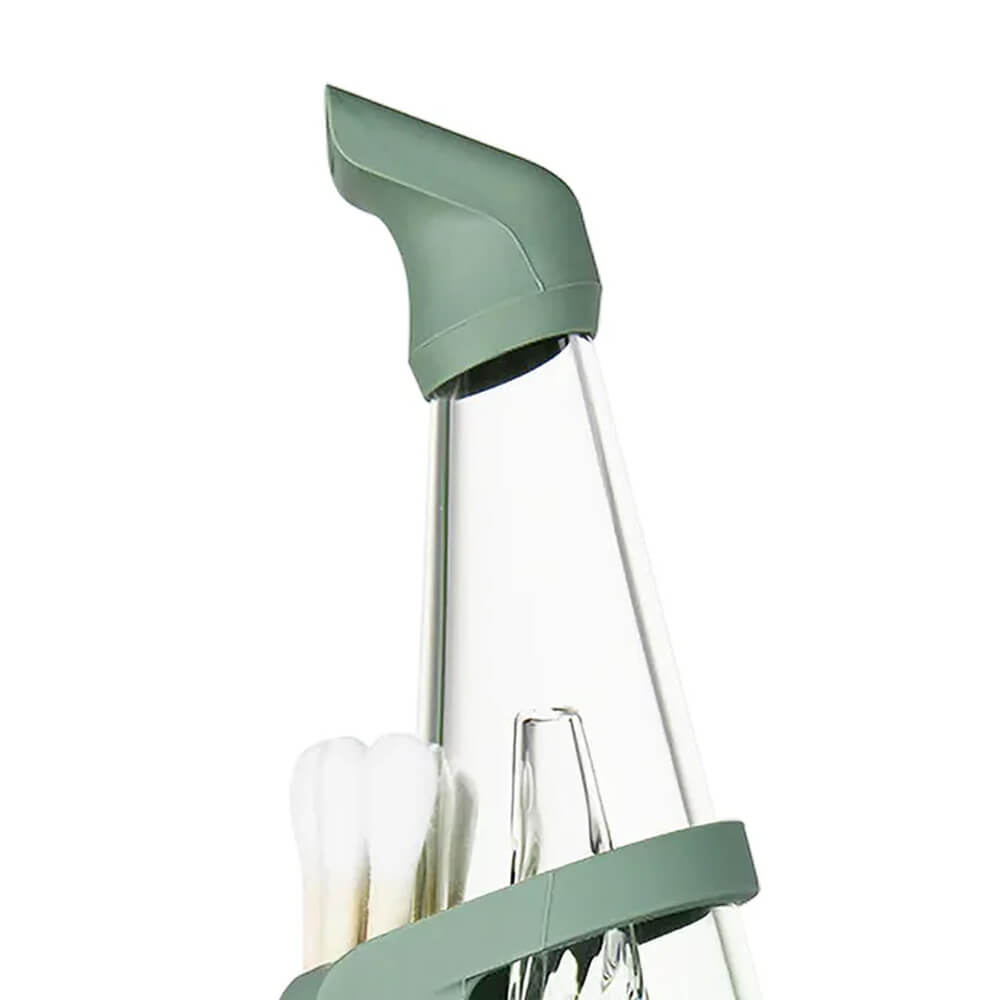 A green-colored object with a pointed top and a clear glass tube, containing a few white objects.