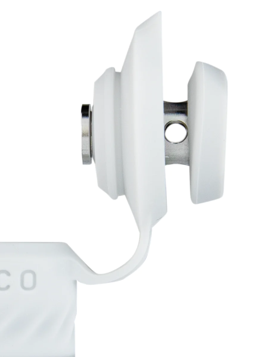 A close-up view of a white plastic object with a silver connector, likely a part of a larger device or appliance.