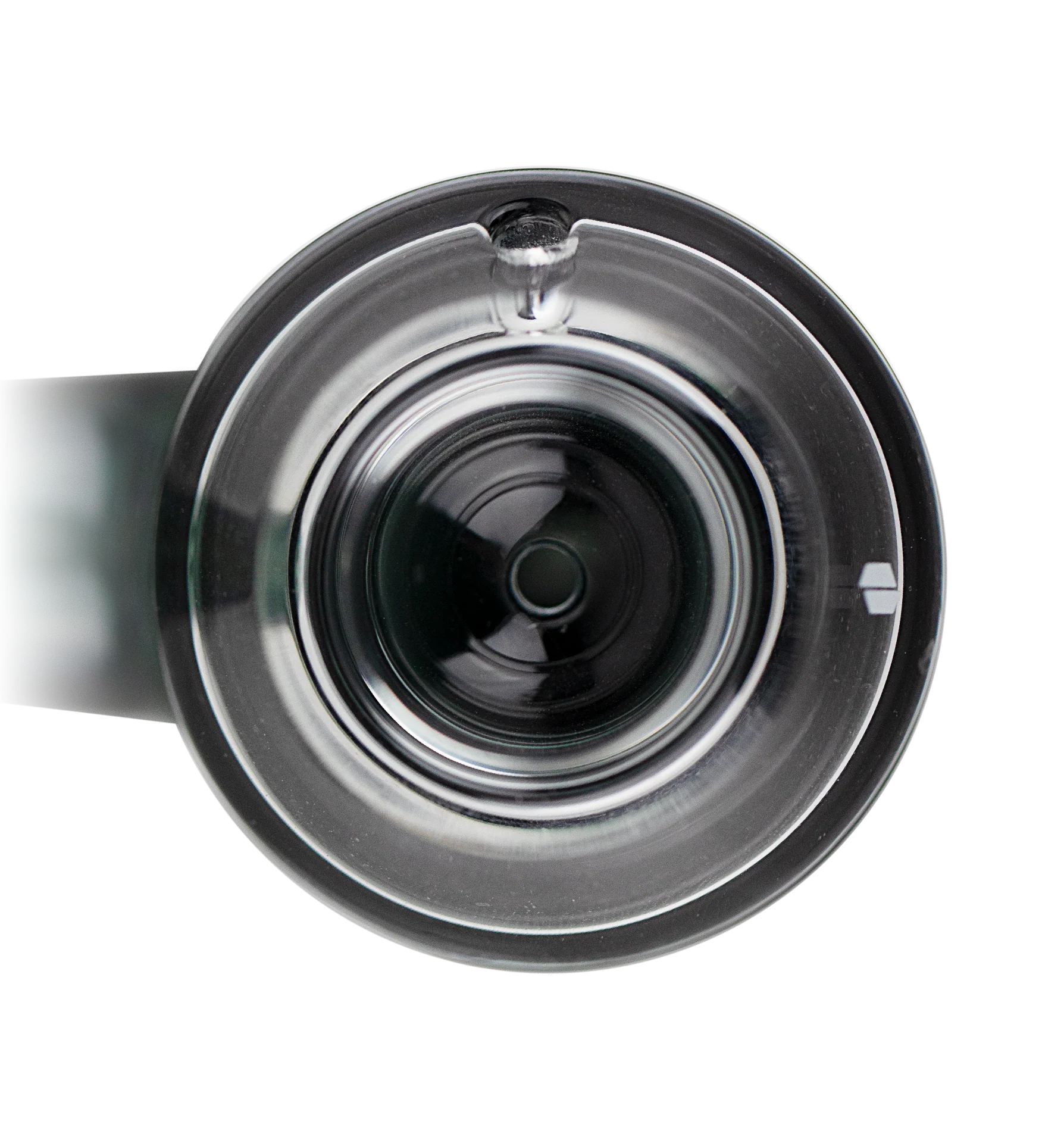 A close-up view of a clear glass container with a small hole in the center, against a black background.