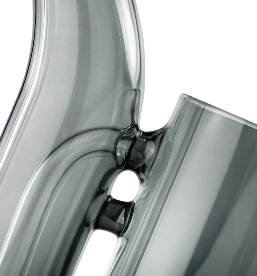 A modern, minimalist black glass sculpture with a curved, pointed shape and a small, round opening at the bottom.