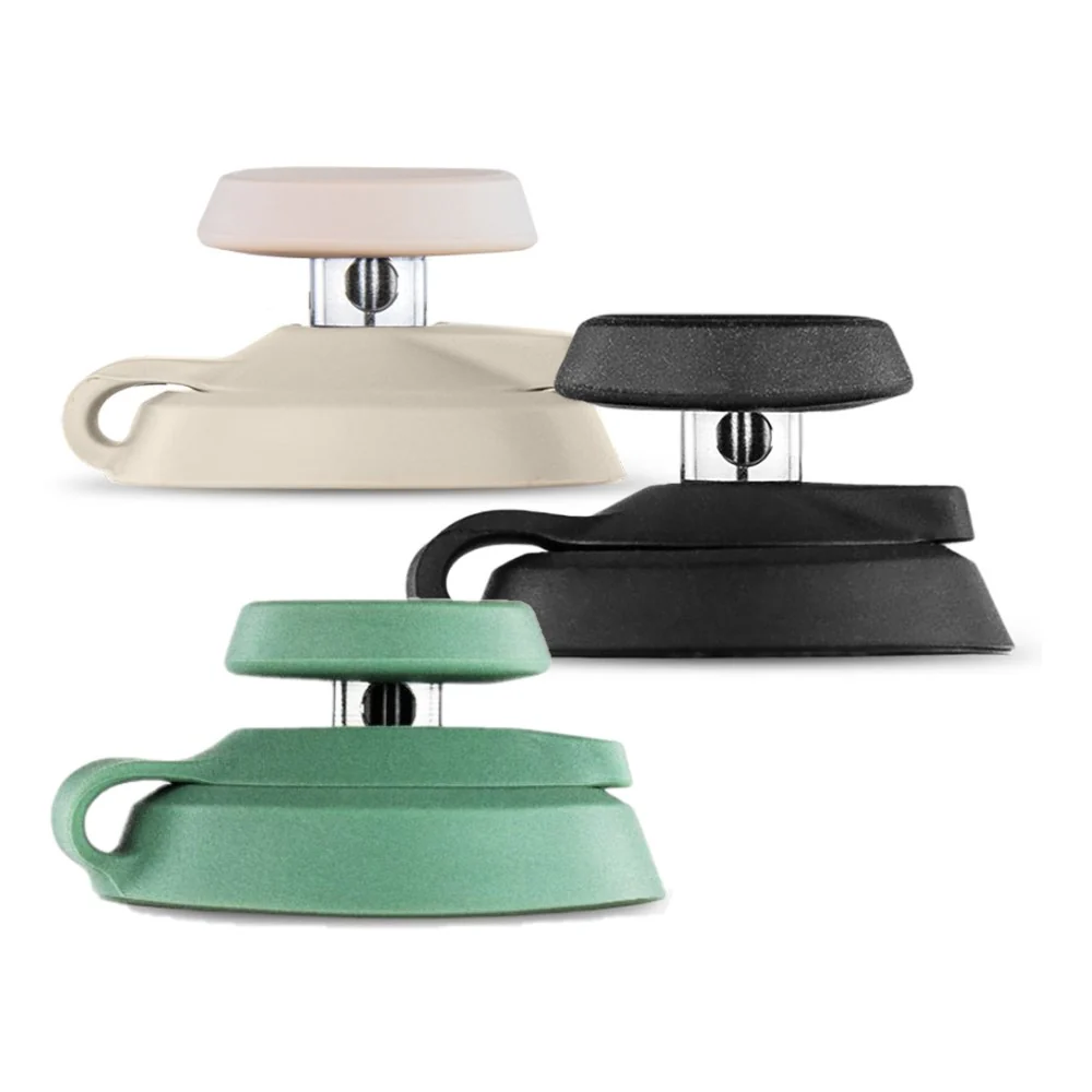 three different colored ceramic or metal objects, including a white object, a beige object, and a black object, arranged in a row.