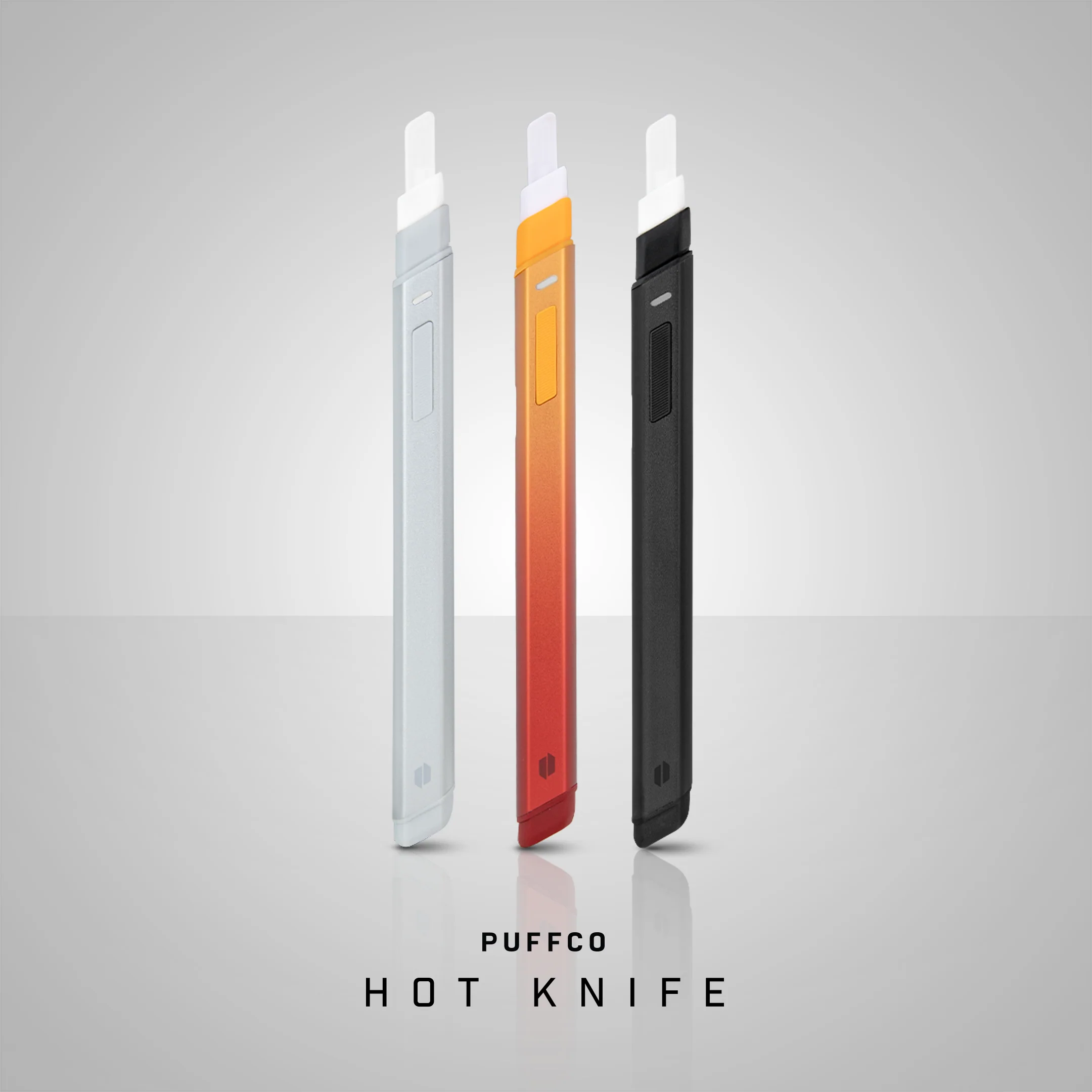 three different colored electronic cigarette devices, including a white, orange, and black device, arranged in a row.
