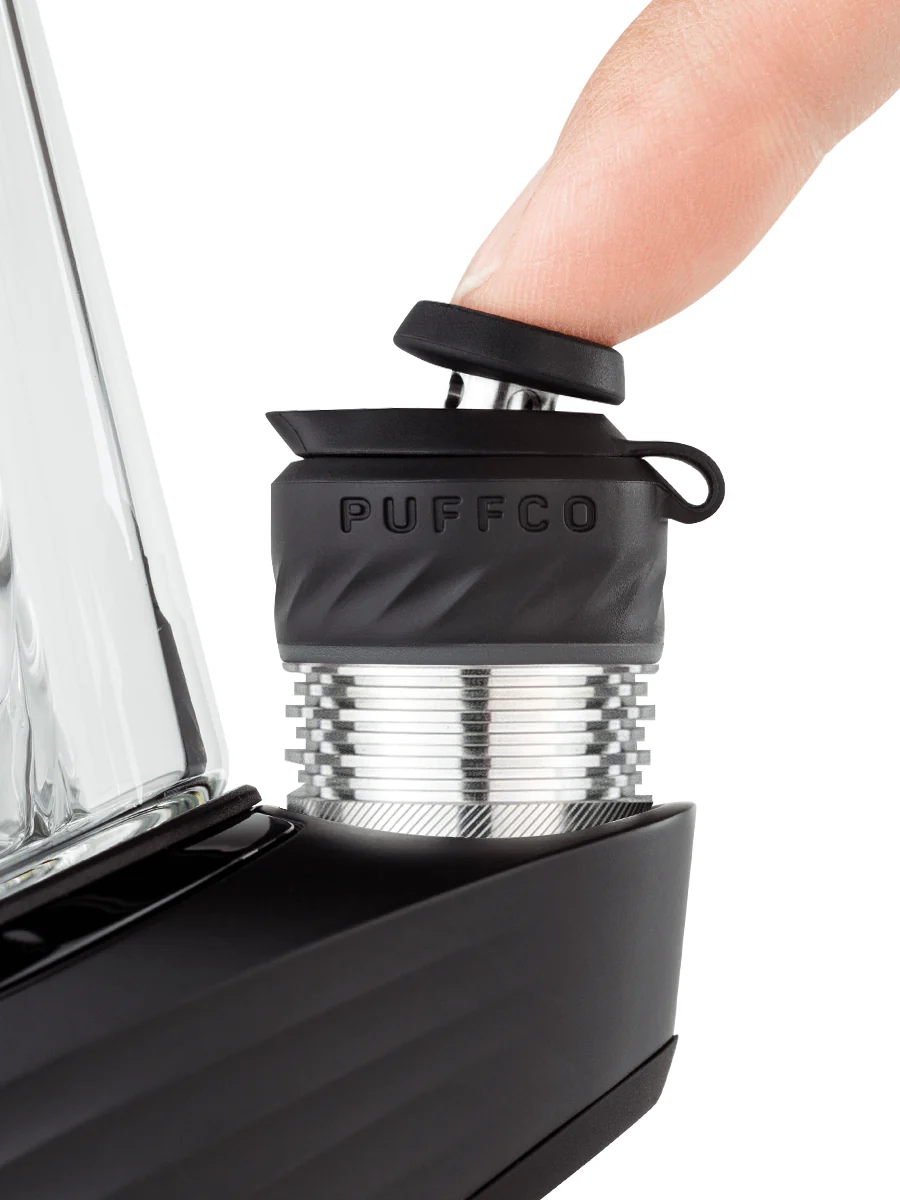 A person's thumb is shown interacting with a black device, which appears to be a piece of electronic equipment.