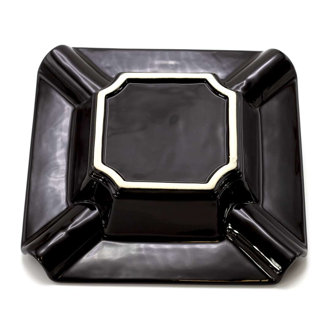 A black rectangular ashtray with a white border.