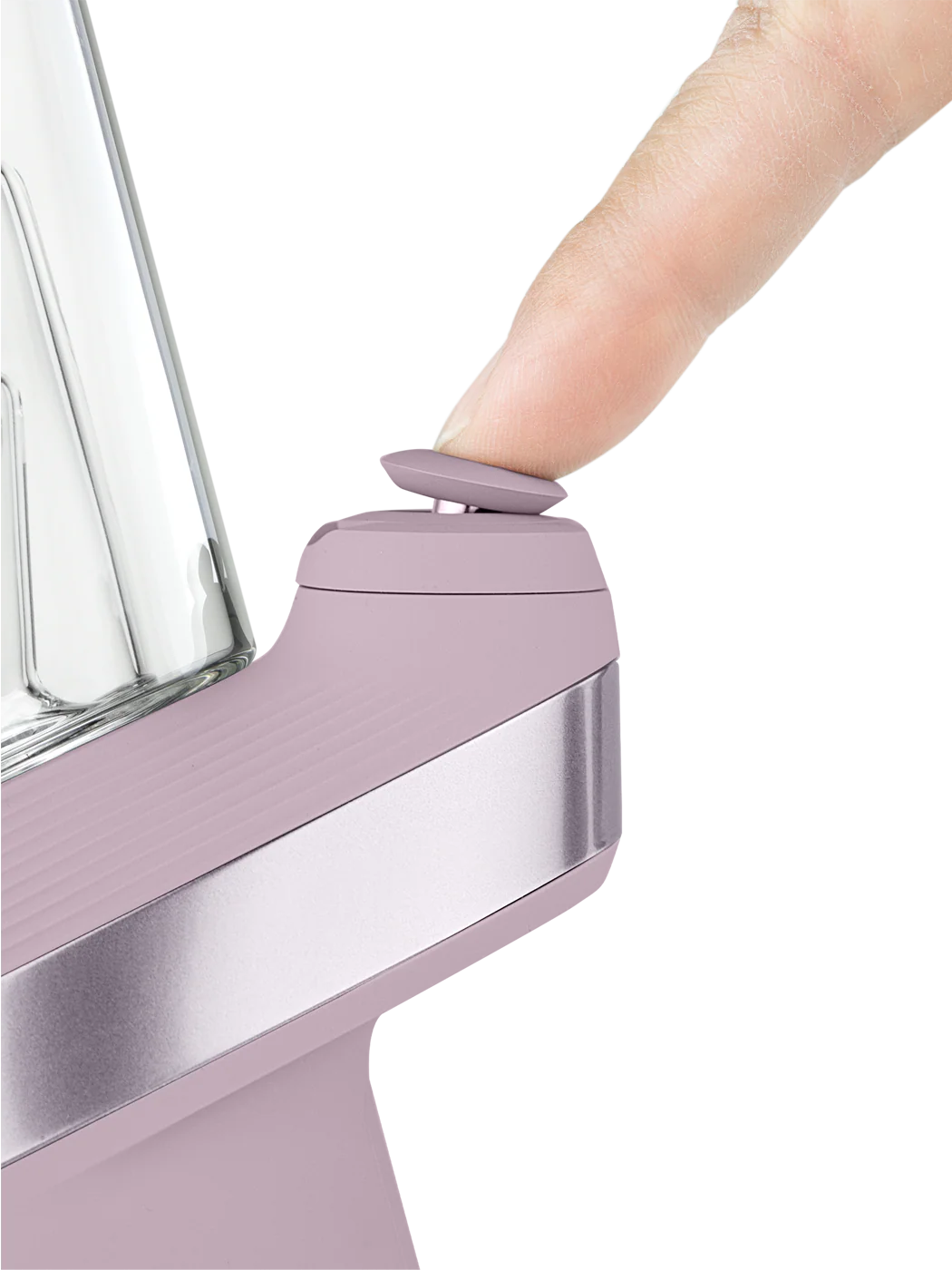 A person's thumb is pressing a button on a purple electronic device, which appears to be a blender or mixer.