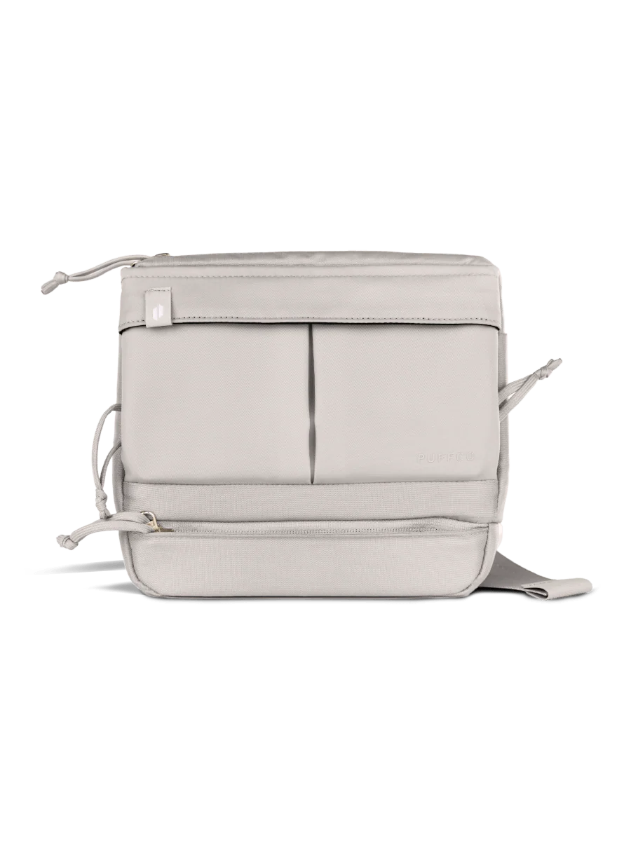 A white, rectangular bag with multiple pockets and zippers, designed for carrying various items.