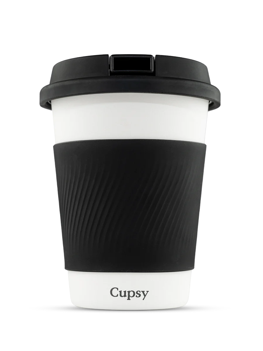 A white and black reusable coffee cup with a black lid and textured grip, against a black background.