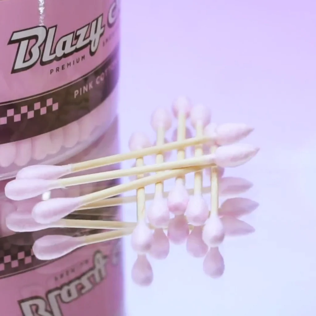 A close-up image of a pink cotton swab with a pink cotton swab stick, arranged in a pattern.