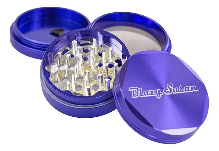 A close-up image of a purple grinder with a clear plastic lid, revealing the metal mesh inside.